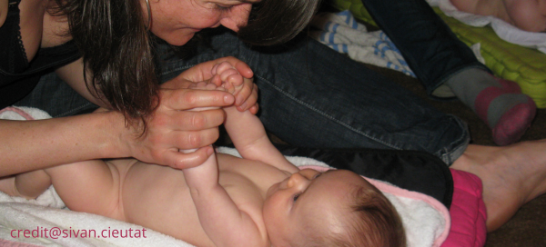 Maman se préparant à masser son bébé connectant par le regard pour lui demander son consentement